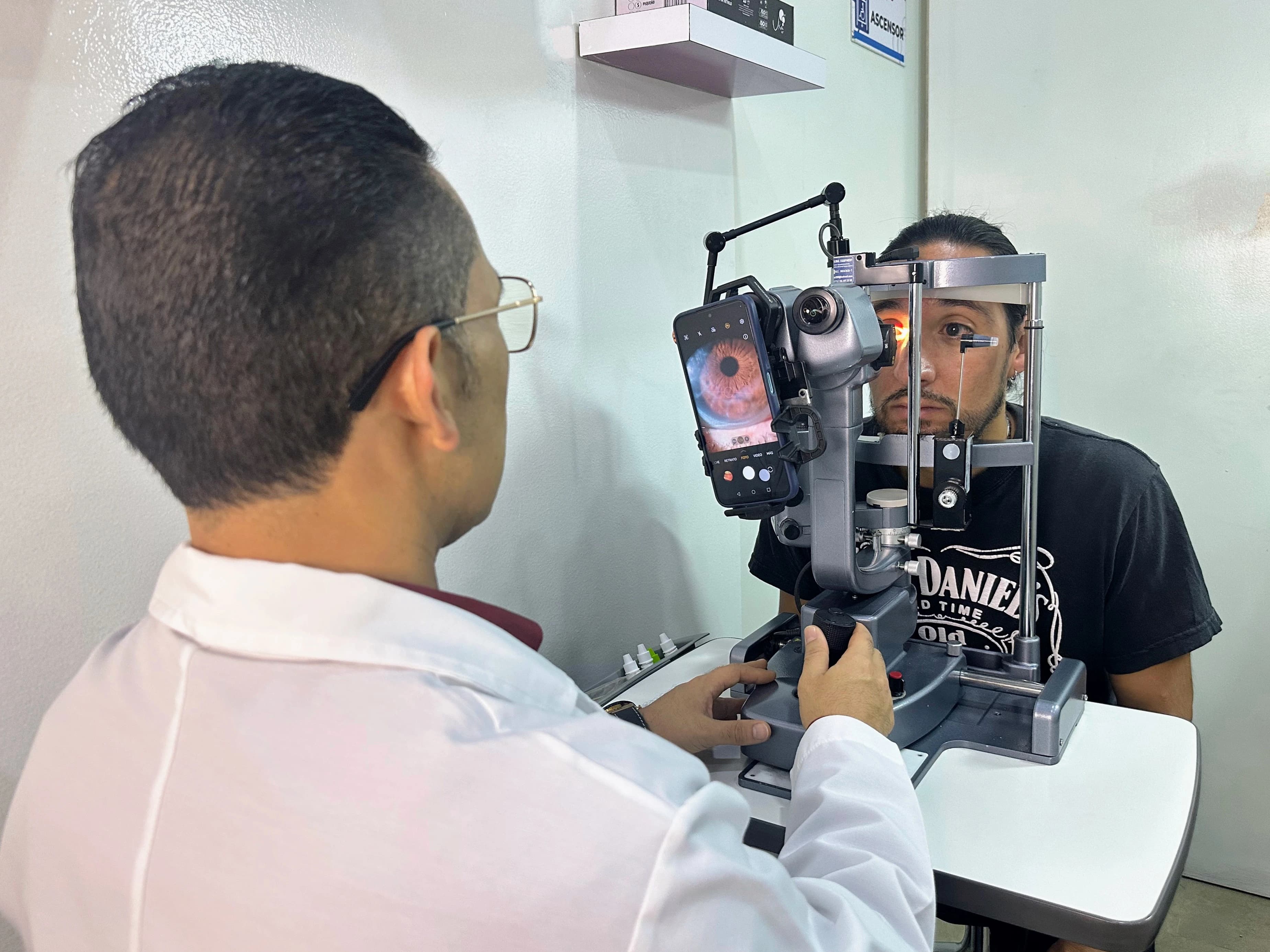 Profesional realizando evaluación visual con equipo diagnóstico en consultorio óptico.